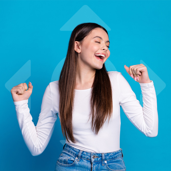 Smiling teen girl wearing braces with fists raised | Bright Orthodontics in Oshkosh, WI
