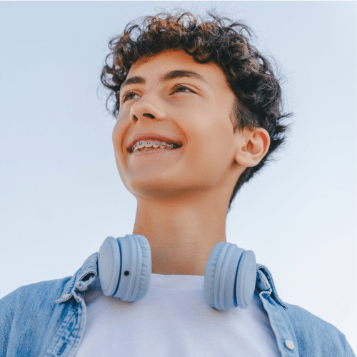 Smiling teen boy looking upward outdoors | Bright Orthodontics in Oshkosh, WI