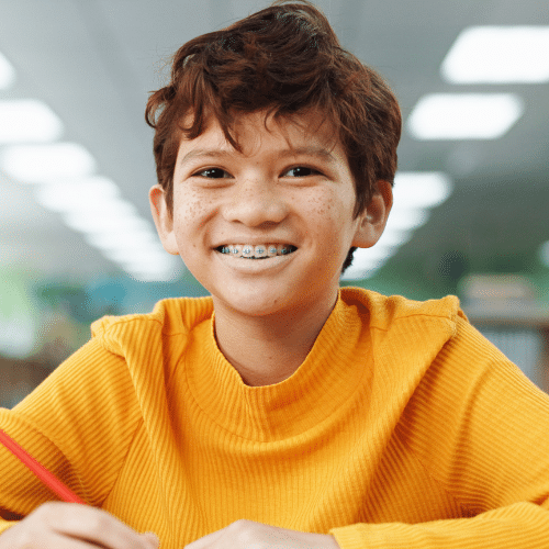 Smiling teen boy wearing backpack at school | Bright Orthodontics in Oshkosh, WI