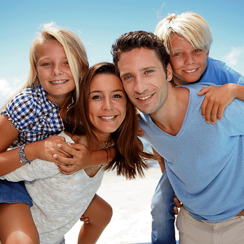 Smiling family of four standing together outdoors | Bright Orthodontics in Oshkosh, WI